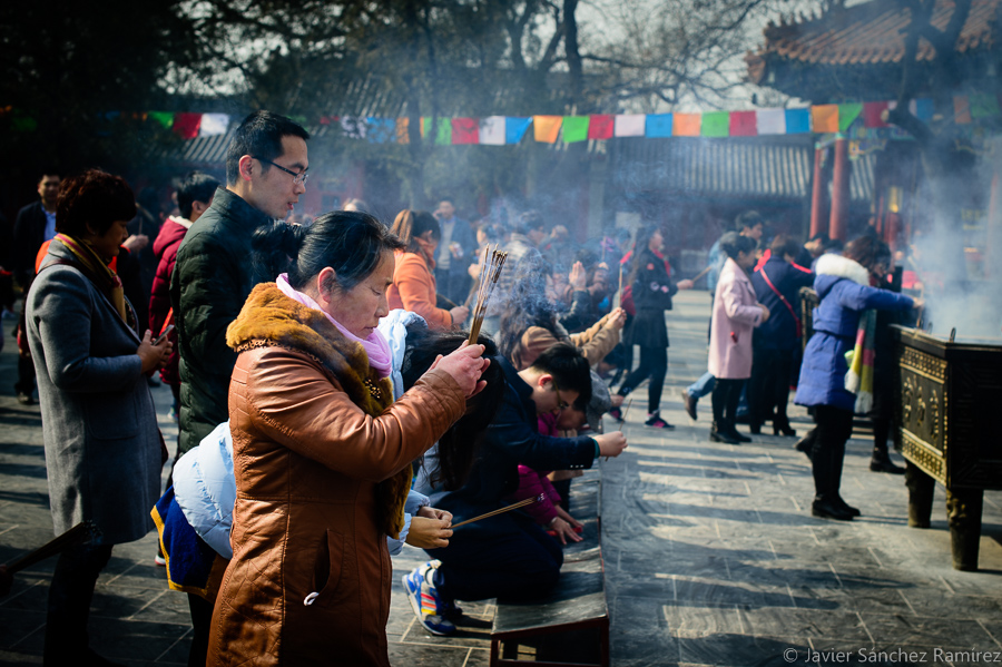Travel photography, pilgrims praying and burning incense at Lama Temple